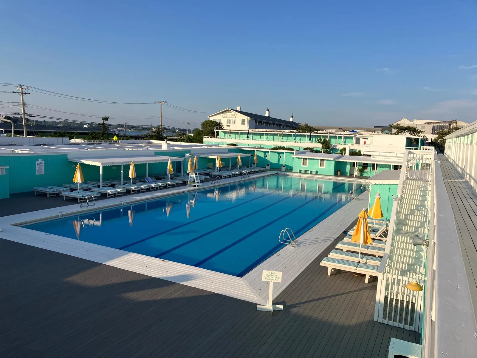 An empty outdoor lap pool at a beach club in early light.